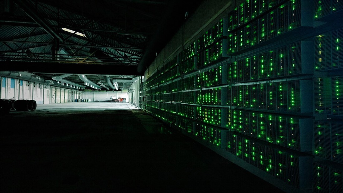Rows of bitcoin mining machines inside a mining farm
